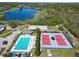 Aerial view of a pool, tennis court, and lake as a part of a recreational facility at 6907 Eagle Ridge Blvd, Lakeland, FL 33813