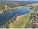 Scenic aerial view of a serene lake surrounded by lush greenery and neighborhood homes at 6907 Eagle Ridge Blvd, Lakeland, FL 33813