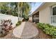 A stone patio overlooks a lush backyard featuring tropical landscaping and a privacy fence at 6907 Eagle Ridge Blvd, Lakeland, FL 33813