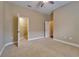 Spacious bedroom with neutral tones, ceiling fan, and open closet, perfect for relaxation and storage at 6907 Eagle Ridge Blvd, Lakeland, FL 33813