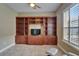 Home office with custom wood built-ins, a flat screen TV, and abundant natural light through window at 6907 Eagle Ridge Blvd, Lakeland, FL 33813