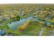 Aerial view of a lake community featuring multiple homes and lush landscaping, and boating docks at 7010 Parliament Pl, Lakeland, FL 33809