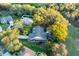Aerial view of a well-maintained home featuring a manicured lawn and mature trees at 7010 Parliament Pl, Lakeland, FL 33809
