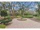 Beautiful backyard with a brick paved patio and well-maintained landscaping including mature trees at 7010 Parliament Pl, Lakeland, FL 33809