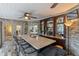 Wet bar features stone walls, granite counters, custom cabinets, and a ceiling fan at 7010 Parliament Pl, Lakeland, FL 33809