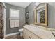 Stylish bathroom features a vanity with granite countertop, neutral wallpaper and tiled shower at 7010 Parliament Pl, Lakeland, FL 33809