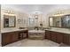 Luxurious bathroom with dual vanities, a soaking tub, and elegant lighting at 7010 Parliament Pl, Lakeland, FL 33809
