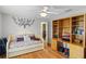 Bedroom with hardwood floors, built-in shelving, and a ceiling fan at 7010 Parliament Pl, Lakeland, FL 33809