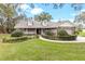 Charming single-story home featuring manicured landscaping, stone accents, dormer windows, and a welcoming front porch at 7010 Parliament Pl, Lakeland, FL 33809