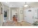 Inviting foyer with decorative light fixture and view into an office with beautiful wood floors at 7010 Parliament Pl, Lakeland, FL 33809