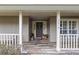 Inviting front porch with wood-look tile, a swing, and a decorative front door at 7010 Parliament Pl, Lakeland, FL 33809