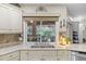 Bright kitchen featuring granite countertops, white cabinetry, and a scenic window view at 7010 Parliament Pl, Lakeland, FL 33809