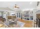 Spacious living room with hardwood floors, a built-in entertainment center, stone fireplace, and an open layout at 7010 Parliament Pl, Lakeland, FL 33809