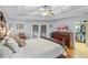 Bedroom featuring hardwood floors, decorative ceiling, ceiling fan, and a view to the ensuite bathroom at 7010 Parliament Pl, Lakeland, FL 33809