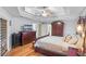 Serene main bedroom with tray ceilings, hardwood floors, a flat-screen TV, and ample closet space at 7010 Parliament Pl, Lakeland, FL 33809