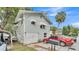 Charming home featuring a two-car garage, red sedan, and tasteful awnings over the upstairs windows at 723 W Patterson St, Lakeland, FL 33803