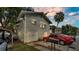 Charming home featuring a two-car garage, red sedan, and tasteful awnings over the upstairs windows at 723 W Patterson St, Lakeland, FL 33803