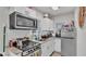 Modern kitchen with stainless steel appliances, granite countertops, and white cabinets at 723 W Patterson St, Lakeland, FL 33803