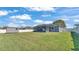 Large backyard features green grass, a screened-in patio, and a storage shed at 8158 Woodvine Cir, Lakeland, FL 33810