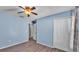 This bedroom features wood-look flooring, a ceiling fan, and blue walls at 8158 Woodvine Cir, Lakeland, FL 33810