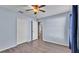 Spacious bedroom with light blue walls, wood-look floors, ceiling fan, and walk-in closet at 8158 Woodvine Cir, Lakeland, FL 33810