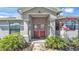 Charming front entrance with a decorative red door, manicured landscaping, and welcoming walkway at 8158 Woodvine Cir, Lakeland, FL 33810