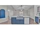 Open kitchen floor plan with a large central island featuring blue cabinetry and a farmhouse sink at 8158 Woodvine Cir, Lakeland, FL 33810