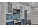 Close up of updated kitchen with stainless steel oven and microwave, blue tiled backsplash at 8158 Woodvine Cir, Lakeland, FL 33810