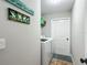 A dedicated laundry room with white washer and dryer, shelf, and door at 8160 Se 164Th Pl, Summerfield, FL 34491