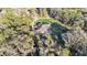 Overhead view of a private home with a screened-in pool, set amidst mature trees and a lush lawn at 9216 Tom Moore Rd, Lakeland, FL 33810