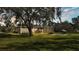 Expansive backyard features a screened lanai, mature trees, and lush grass creating a serene outdoor space at 9216 Tom Moore Rd, Lakeland, FL 33810