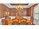 Formal dining room boasts wainscoting, hardwood floors, and an elegant chandelier at 9216 Tom Moore Rd, Lakeland, FL 33810