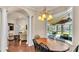 Sunlit dining room with hardwood floors, chandelier, and views of the screened in pool at 9216 Tom Moore Rd, Lakeland, FL 33810