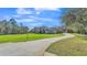 Well-maintained property featuring a long driveway, expansive lawn, and professionally landscaped front yard at 9216 Tom Moore Rd, Lakeland, FL 33810