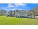 Stunning single-story home with lush landscaping, a three-car garage, and grey exterior at 9216 Tom Moore Rd, Lakeland, FL 33810
