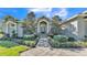 Elegant home entrance with a stone walkway, decorative columns, and lush landscaping creates a welcoming approach at 9216 Tom Moore Rd, Lakeland, FL 33810