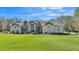 Charming single-story home featuring stone accents and a meticulously manicured front yard with a vibrant green lawn at 9216 Tom Moore Rd, Lakeland, FL 33810