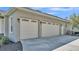 Three-car garage featuring white doors with decorative windows and lantern style lighting at 9216 Tom Moore Rd, Lakeland, FL 33810
