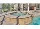 In-ground hot tub and outdoor kitchen create a luxurious outdoor living experience at 9216 Tom Moore Rd, Lakeland, FL 33810