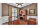 This home office features rich wood furniture, hardwood floors and plantation shutters for natural light at 9216 Tom Moore Rd, Lakeland, FL 33810