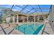 A luxurious backyard with a screened-in pool, spa, and well-maintained landscaping at 9216 Tom Moore Rd, Lakeland, FL 33810