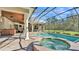 Gorgeous backyard pool and spa under a screened enclosure with lush landscaping at 9216 Tom Moore Rd, Lakeland, FL 33810