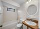 Bathroom with a granite vanity, a round mirror, and a shower and tub at 1064 Penguin Pl, Lakeland, FL 33809