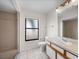 Bathroom featuring tiled shower, commode and a vanity with sink, and window at 1064 Penguin Pl, Lakeland, FL 33809