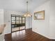 Dining area with hardwood floors, a chandelier, and glass doors to the enclosed porch at 1064 Penguin Pl, Lakeland, FL 33809