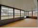 The enclosed porch features neutral carpet, a white ceiling, and multiple sliding windows at 1064 Penguin Pl, Lakeland, FL 33809