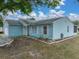 Charming single-story home with light blue siding, attached garage, and well-manicured landscaping at 1064 Penguin Pl, Lakeland, FL 33809