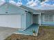 Exterior view of a home with a two-car garage and well-maintained landscaping at the front entrance at 1064 Penguin Pl, Lakeland, FL 33809