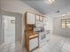 Bright kitchen area featuring sleek white appliances and warm brown granite countertops at 1064 Penguin Pl, Lakeland, FL 33809