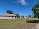 A view of the exterior of the home with a grass yard and screened in porch at 107 Amber Blvd, Auburndale, FL 33823